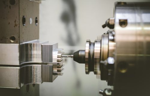 Cutting tool of a CNC machine performing precision machining of a metal part held in the machine chuck.