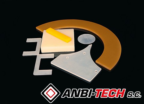 Various precision plastic components of different shapes and colours arranged on a black background.