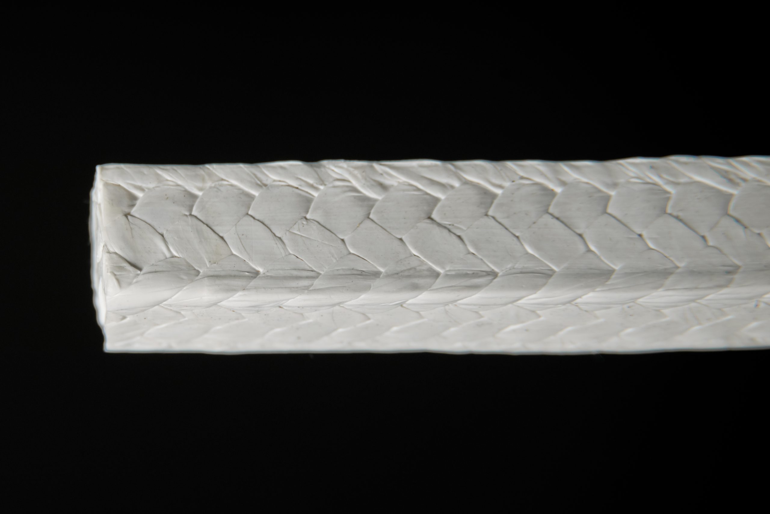 Macro close-up of white PTFE packing with fishbone braid - 8-strand herringbone structure